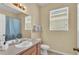 Bathroom with a single vanity, large mirror, and shower with blue curtain at 7759 Basnett Cir, Kissimmee, FL 34747