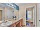 Bright bathroom featuring a double vanity, large mirror, and shower with themed curtain at 7759 Basnett Cir, Kissimmee, FL 34747