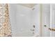 Full tub and shower combination with white tiled walls at 7759 Basnett Cir, Kissimmee, FL 34747