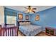Bedroom boasts a queen bed, crib and light-blue painted walls at 7759 Basnett Cir, Kissimmee, FL 34747