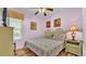 Comfortable bedroom featuring light purple walls, a ceiling fan, and a window with white blinds and colorful valance at 7759 Basnett Cir, Kissimmee, FL 34747