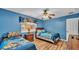 Bright bedroom featuring two twin beds, hardwood floors, and a ceiling fan at 7759 Basnett Cir, Kissimmee, FL 34747