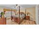 Bedroom with wooden four poster bed, ceiling fan and wooden floors and dresser with lamps on both sides of the bed at 7759 Basnett Cir, Kissimmee, FL 34747