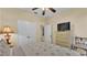 Bedroom featuring ceiling fan, neutral walls and floors with dresser and chair with decorative pillows at 7759 Basnett Cir, Kissimmee, FL 34747