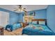 Bedroom features two twin beds with bright blue walls and a ceiling fan at 7759 Basnett Cir, Kissimmee, FL 34747