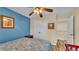 This bedroom features a ceiling fan, closet, and calming blue accent wall at 7759 Basnett Cir, Kissimmee, FL 34747