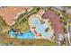 An aerial view showcases the community pool, splash pad, and surrounding landscaping at 7759 Basnett Cir, Kissimmee, FL 34747