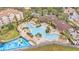 Resort-style community pool with lounge chairs, umbrellas, and tropical landscaping at 7759 Basnett Cir, Kissimmee, FL 34747