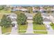 A beautifully landscaped suburban home with a well-manicured lawn, driveway, and mature shade trees at 7759 Basnett Cir, Kissimmee, FL 34747