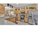 Well-lit kitchen features stainless steel appliances and light wood cabinetry at 7759 Basnett Cir, Kissimmee, FL 34747