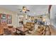 Inviting living room showcasing a ceiling fan, neutral walls, and an open layout connecting to the kitchen and dining areas at 7759 Basnett Cir, Kissimmee, FL 34747