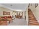 Open-concept living area featuring a staircase, comfortable seating, and a dining area, ideal for entertaining at 7759 Basnett Cir, Kissimmee, FL 34747