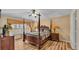 Beautiful main bedroom with a four-poster bed, warm colors, and hardwood floors at 7759 Basnett Cir, Kissimmee, FL 34747