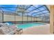 A screened in pool area with lounge chairs and patio, ready for summer fun at 7759 Basnett Cir, Kissimmee, FL 34747