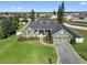 Stunning aerial view of home featuring a manicured lawn, brick driveway, mature trees, and a fenced-in backyard at 819 Hart Lake St, Winter Haven, FL 33884