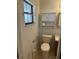 Cozy half bathroom with toilet, cabinet, mirror, and natural lighting at 907 Van Dr, Auburndale, FL 33823