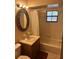Cozy bathroom featuring a shower-tub combo, vanity with an ornate mirror, and natural light at 907 Van Dr, Auburndale, FL 33823
