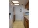 Galley kitchen with ample cabinet space, white appliances and vinyl floors at 907 Van Dr, Auburndale, FL 33823