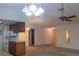 Open-concept living area with ceiling fans, connecting kitchen, and neutral-colored carpet at 907 Van Dr, Auburndale, FL 33823