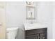 A bathroom featuring a modern vanity with granite counters and a decorative framed mirror at 91 W Cedarwood Cir, Kissimmee, FL 34743