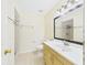 Bathroom showcasing a wooden vanity with mirror and lighting, along with a toilet and shower at 91 W Cedarwood Cir, Kissimmee, FL 34743