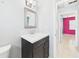 A bathroom featuring a modern vanity with granite counters, framed mirror, and bright accent wall at 91 W Cedarwood Cir, Kissimmee, FL 34743