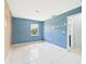 An empty bedroom showing tiled floors, an exterior window, and a partially painted wall at 91 W Cedarwood Cir, Kissimmee, FL 34743