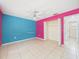Spacious bedroom showing tiled floors, ceiling fan, and a bright accent wall at 91 W Cedarwood Cir, Kissimmee, FL 34743