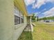 Exterior shot of a single story house with a light green color and a window with blinds at 91 W Cedarwood Cir, Kissimmee, FL 34743