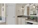 Bathroom with double vanity, granite countertops, and decorative mirrors at 9502 Waterford Oaks Blvd, Winter Haven, FL 33884