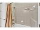 Bathroom featuring a shower with a tan curtain, tile surround, and a view of the showerhead at 9502 Waterford Oaks Blvd, Winter Haven, FL 33884