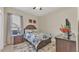 Bright bedroom with hardwood floors, neutral walls, and floral bedding at 9502 Waterford Oaks Blvd, Winter Haven, FL 33884