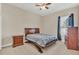 Bedroom with neutral walls, carpet, ceiling fan, and wood furnishings for a warm, inviting space at 9502 Waterford Oaks Blvd, Winter Haven, FL 33884
