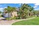 Beautifully landscaped home exterior with lush tropical plants, manicured lawn and brick walkway at 9502 Waterford Oaks Blvd, Winter Haven, FL 33884