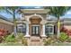 Stunning home facade with stately columns, arched entryway, and beautiful landscaping at 9502 Waterford Oaks Blvd, Winter Haven, FL 33884