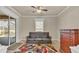 Cozy room with couch, colorful rug, and dresser; sliding doors open to a pool area at 9502 Waterford Oaks Blvd, Winter Haven, FL 33884