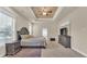 Spacious main bedroom with neutral walls, carpet, tray ceilings, ceiling fan, and stylish furnishings at 9502 Waterford Oaks Blvd, Winter Haven, FL 33884