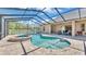 Screened-in pool area with inground pool, spa, and brick-paved patio at 9502 Waterford Oaks Blvd, Winter Haven, FL 33884