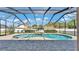 Beautiful screened-in pool and spa with brick patio and landscaped backyard at 9502 Waterford Oaks Blvd, Winter Haven, FL 33884
