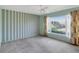 Bedroom with wallpapered walls, ceiling fan, and a large bright window with garden views at 995 14Th Ne St, Winter Haven, FL 33881