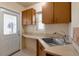 Small kitchenette area with cabinetry, sink, tile countertop, and exterior access door at 995 14Th Ne St, Winter Haven, FL 33881