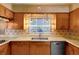 Close up of the kitchen showcasing the wood cabinetry, tile countertops, and stainless steel sink at 995 14Th Ne St, Winter Haven, FL 33881