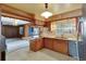 View of the kitchen with tile floors, wood cabinetry, tile countertops, and stainless steel appliances at 995 14Th Ne St, Winter Haven, FL 33881