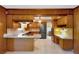 Wide view of the kitchen with stainless steel appliances, wood cabinetry, and tile floors at 995 14Th Ne St, Winter Haven, FL 33881