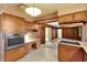 View of the kitchen showcasing the wood cabinetry, built in oven, and adjoining living area at 995 14Th Ne St, Winter Haven, FL 33881