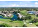 Scenic aerial view of a community with a pond, red-roofed buildings, a golf course, and lush greenery at 1104 Country Club Dr # A-4, Lake Wales, FL 33898