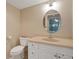 Cozy bathroom featuring a single sink vanity, oval mirror, and standard toilet at 1104 Country Club Dr # A-4, Lake Wales, FL 33898
