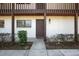 Inviting condo entrance with a wooden door, outdoor lighting, and tidy landscaping at 1104 Country Club Dr # A-4, Lake Wales, FL 33898