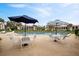 Community pool with umbrella-covered tables and comfortable lounge chairs for residents to enjoy at 1104 Country Club Dr # A-4, Lake Wales, FL 33898