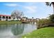 Water view of the condo complex with lush landscaping and a wooden bridge walkway at 1104 Country Club Dr # A-4, Lake Wales, FL 33898
